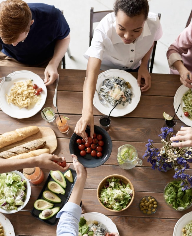 family members sitting at a table eating a meal