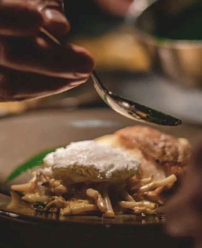 chef adding a sauce to a plated meal