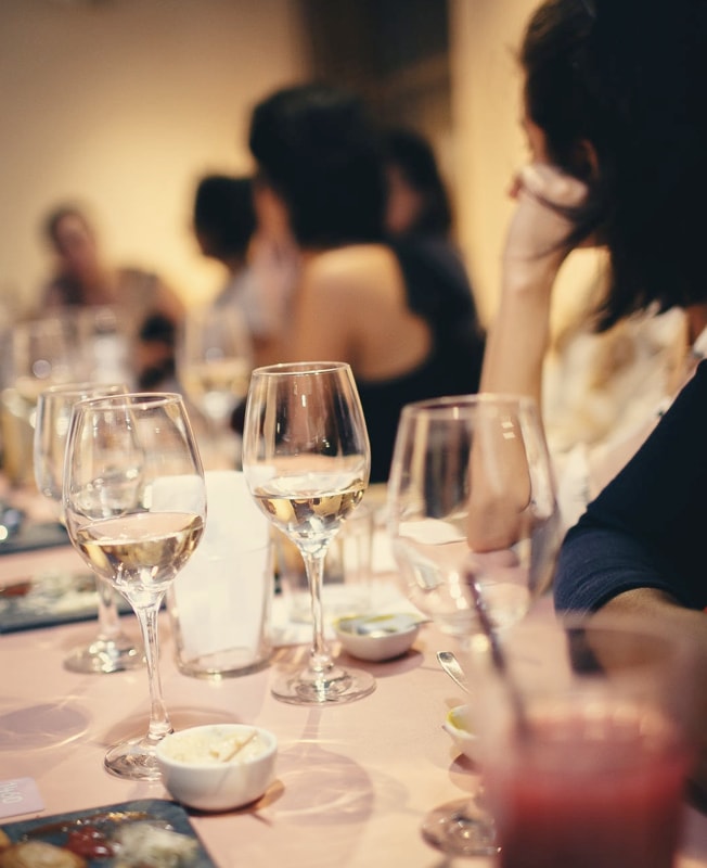 people sitting at a table listening to a woman speaking